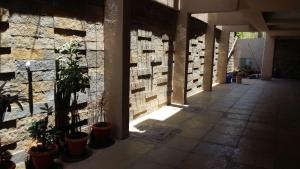 un corridoio con piante in vaso e un muro di mattoni di Pandharinath Lodge a Pandharpur