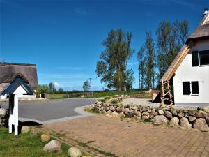 a house and a stone wall next to a road at Freistehende Ferienwohnung in Rerik mit Sauna in Rerik