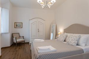 a bedroom with a bed and a chair and a chandelier at Mercatale Apartment in Prato