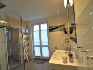 a bathroom with a sink and a glass shower at Freistehende Ferienwohnung in Rerik mit Sauna in Rerik +32 photos