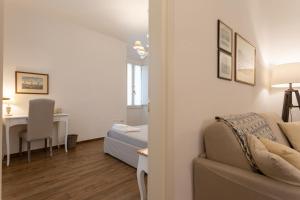 a living room with a couch and a desk in a room at Mercatale Apartment in Prato