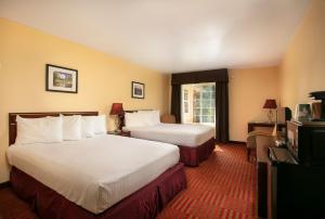 a hotel room with two beds and a television at The Monarch Inn in Mariposa