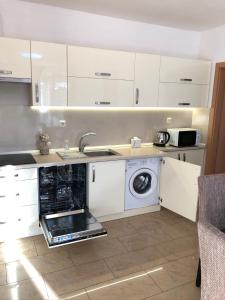una cocina con fregadero y lavadora en Casa Blanca, en Nyíregyháza