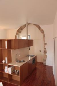 una cocina con fregadero y un arco de piedra en Casa do Arco, Santarém, en Santarém