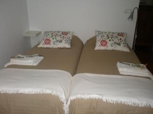 Una cama con dos almohadas encima. en Casa do Arco, Santarém, en Santarém
