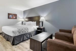 a hotel room with a bed and a couch at Super 8 by Wyndham Macleod Trail Calgary in Calgary