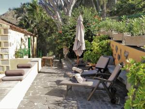 a patio with an umbrella and a chair and an exercising apparatus at Finca Doña Juana in Los Realejos