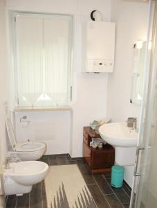 bagno bianco con servizi igienici e lavandino di La Casetta di Alvaro a Domegliara