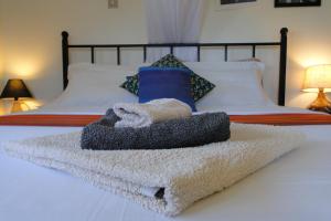 een stapel handdoeken bovenop een bed bij Carpe Diem Guesthouse in Entebbe