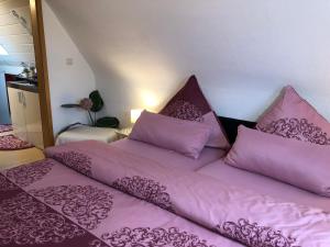 two beds in a room with purple sheets and pillows at Pension Haus Barbara Oberhof in Oberhof