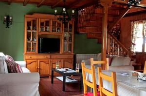 Noriega的住宿－El bordón de Noriega，客厅配有沙发和带电视的桌子