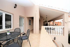 a balcony of a house with a table and chairs at Villa Allegro in Sukošan