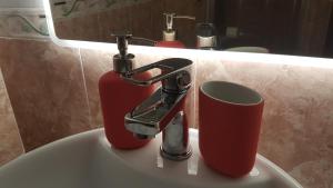 a bathroom sink with a faucet and a cup at Piccolo Poggio Apartments in Florence