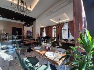 ein Esszimmer mit Tischen und Stühlen und eine Küche in der Unterkunft Hotel Kloest in Durrës