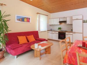 a living room with a red couch and a table at Holiday home in the Gro breitenbach in Altenfeld