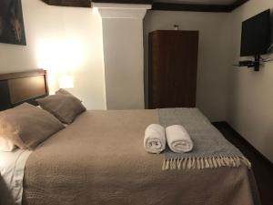 a bedroom with a pair of shoes on the bed at Lucia Agustina Hotel Boutique in Santiago