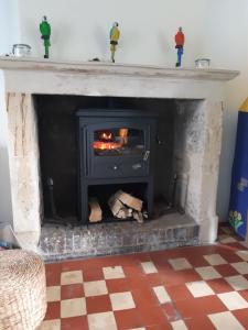 a fireplace with a fire in it in a living room at Maison avec jardin, près plages du débarquement, table ping pong, à 800 m d' Omaha beach adaptée jeunes enfants in Vierville-sur-Mer