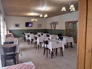 a dining room with white tables and chairs at Hotel Alonso in Río Gallegos