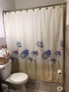 a bathroom with a shower curtain with blue flowers on it at The Rex Motel At Niagara Falls in Niagara Falls