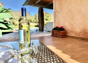 una botella de vino sentada en una mesa con copas en Villa Ibiscus, en Cannigione