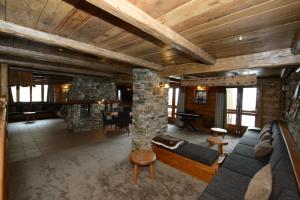 a living room with a stone fireplace in a house at Chalet La Becca in Le Fornet
