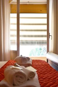 1 dormitorio con 1 cama con toallas y ventana en Edo House Monteverde en Roma