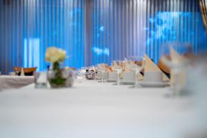 ヴァーレンドルフにあるHotel Emshofの白いテーブルクロスと青いカーテン付きのテーブル