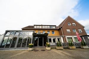 un bâtiment avec un devant de magasin avec des plantes devant lui dans l'établissement Hotel Emshof, à Warendorf