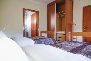 a bedroom with two beds and a closet at Alojamento Local do Arado in Bragança
