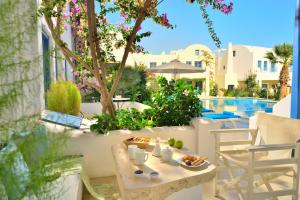 a table with food on it next to a pool at Tamarix Del Mar Suites in Kamari