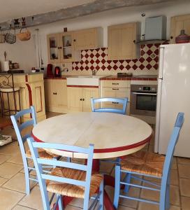 コロブリエールにあるLa petite châtaigne de Collobrièresのキッチン(テーブル、椅子、冷蔵庫付)