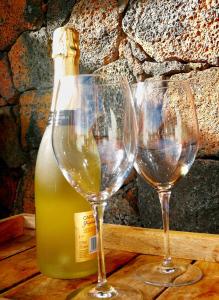 two wine glasses sitting next to a bottle of wine at Villa Shepherd Lajares - LUXURY VILLA FUERTEVENTURA in Lajares