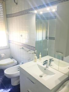 Baño blanco con lavabo y aseo en Edo House Monteverde en Roma