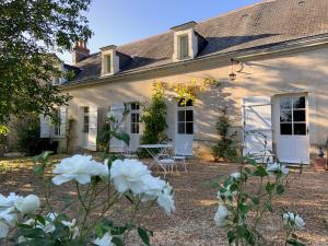 una casa blanca con flores blancas delante en La Cour du Liège-Charming renovated country estate en Clefs-Val d'Anjou