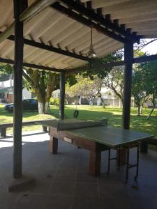 una mesa de ping pong bajo un pabellón con una pelota de ping pong en Chacara Estrela do Mar en Peruíbe