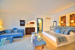a bedroom with two beds and a living room at Tamarix Del Mar Suites in Kamari