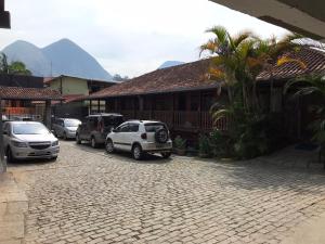 a street with cars parked in front of a building at Hotel Montanus in Nova Friburgo