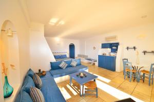a living room with a blue couch and a table at Tamarix Del Mar Suites in Kamari