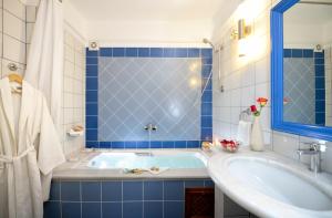 a blue and white bathroom with a tub and a sink at Tamarix Del Mar Suites in Kamari