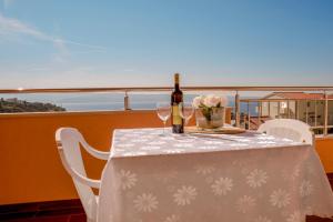 a table with a bottle of wine and two glasses at Apartment Alja, Sara i Nevio jacuzzi in Dugi Rat