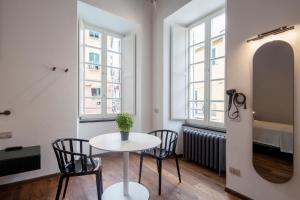 a table and chairs in a room with two windows at Piccolo Principe Affittacamere in Monterosso al Mare
