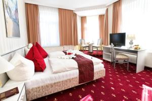 梅拉納的住宿－Parkhotel Meerane，酒店客房设有一张大床和一张书桌。