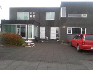 een rood busje geparkeerd voor een huis bij Thorshamar - Car Included in Reykjavík