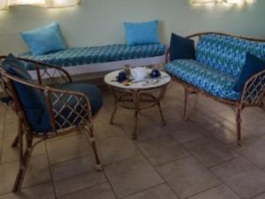 a living room with two couches and a table and chairs at Jacoway Inn in Calibishie