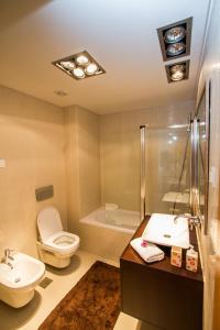 a bathroom with a toilet and a sink and a tub at Madeira Luxury Villas Living Funchal in Funchal