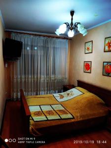 - une chambre avec un grand lit et une télévision dans l'établissement Просторная квартира в центре Тирасполя!, à Tiraspol