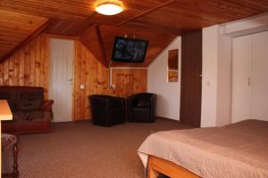 a bedroom with a bed and a flat screen tv at Vila Bellmont in Predeal