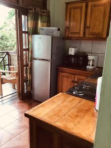 a kitchen with a white refrigerator and wooden cabinets at Alibaba‘s Seabreeze in Castara