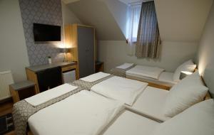 a hotel room with two beds and a desk at Dolce Vita Panzió in Miskolc