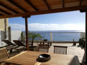 een patio met een tafel en stoelen en de oceaan bij Residencial LaMar in Santa Cruz de la Palma